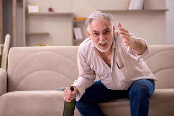 Vieil homme buvant de l'alcool à la maison — Photo