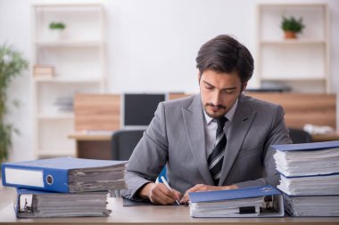 Ofisteki aşırı işten memnun olmayan genç bir erkek işçi.