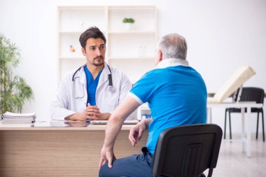 Yaşlı boyun yaralı erkek hasta genç erkek doktoru ziyaret ediyor.