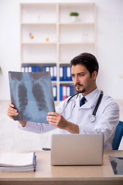 Ung manlig röntgenläkare som arbetar på kliniken — Stockfoto