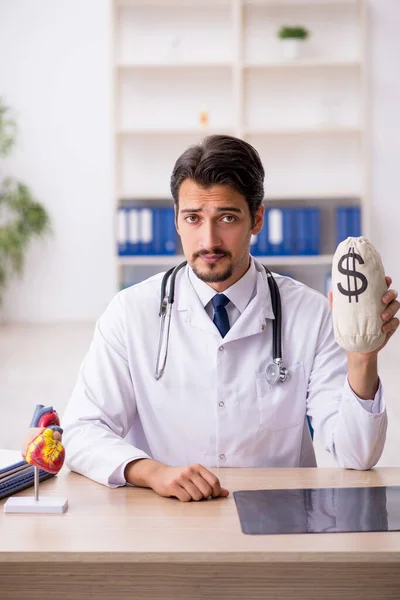 Fiatal férfi orvos kardiológus gazdaság monebag — Stock Fotó