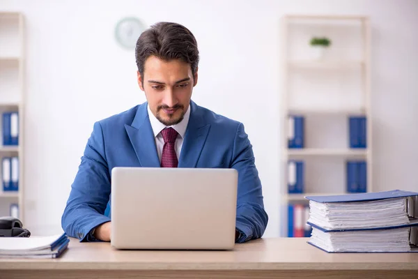 Joven empleado masculino descontento con el trabajo excesivo en la oficina — Foto de Stock