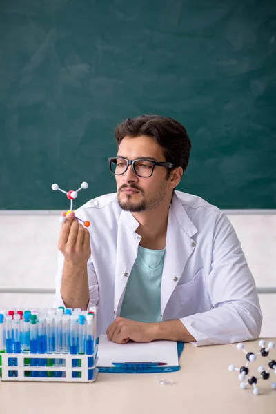 Jonge mannelijke chemicus voor schoolbord — Stockfoto