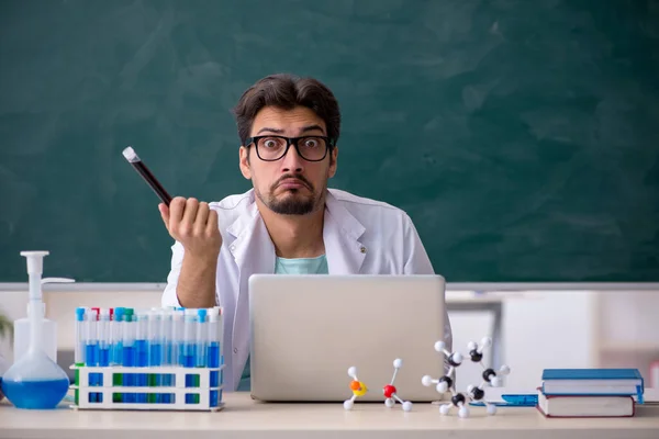 Jonge mannelijke chemicus voor schoolbord — Stockfoto