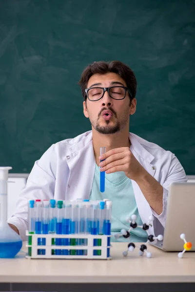 Jonge mannelijke chemicus voor schoolbord — Stockfoto