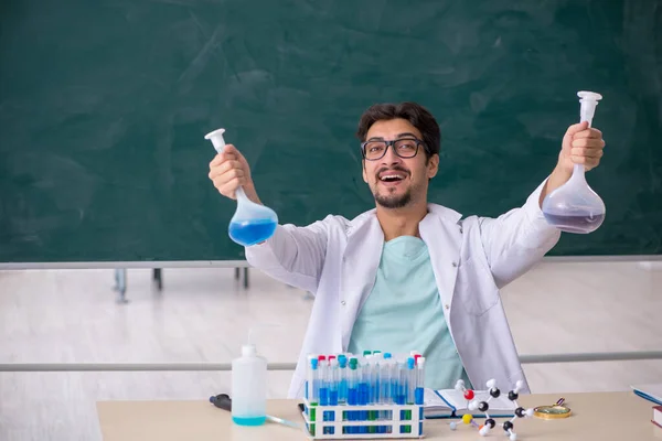 Junger Chemiker vor der Tafel — Stockfoto