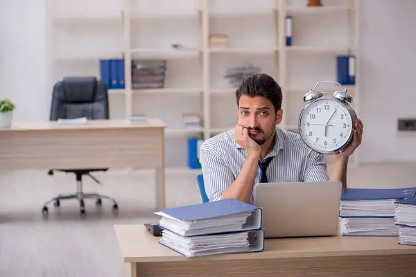 Joven empleado masculino en concepto de gestión del tiempo —  Fotos de Stock