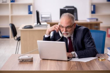 Ofiste çalışan yaşlı bir erkek.