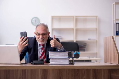 Ofiste çalışan yaşlı bir erkek.