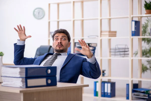 Jeune employé masculin et trop de travail au bureau — Photo