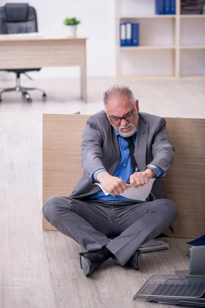 Oude mannelijke werknemer ongelukkig met overmatig werk in het kantoor — Stockfoto