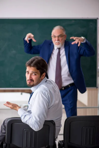 Oude mannelijke leraar en jonge mannelijke student voor het groene bord — Stockfoto