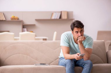 Evde televizyon izleyen genç bir öğrenci.