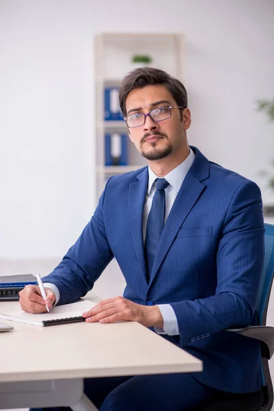 Jovem funcionário masculino e muito trabalho no escritório — Fotografia de Stock