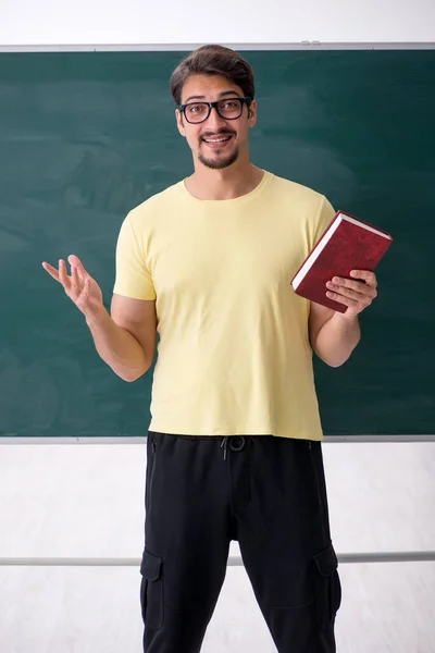 Jonge mannelijke student voor schoolbord — Stockfoto