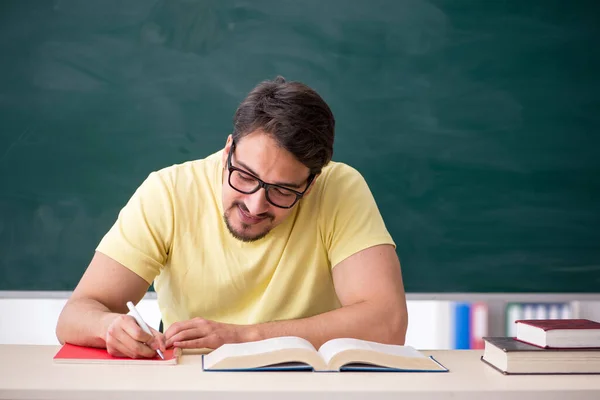 Ung manlig student framför svarta tavlan — Stockfoto