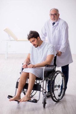 Yaşlı erkek doktor psikiyatristi engelli hastaları muayene ediyor.