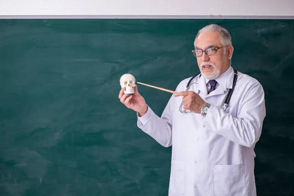 Tahtanın önünde yaşlı doktor öğretmen. — Stok fotoğraf