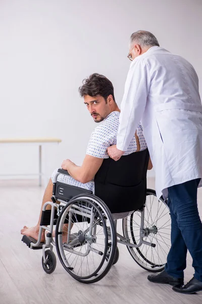 Anciano médico psiquiatra examinando joven discapacitado paciente — Foto de Stock