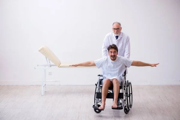 Anciano médico psiquiatra examinando joven discapacitado paciente —  Fotos de Stock