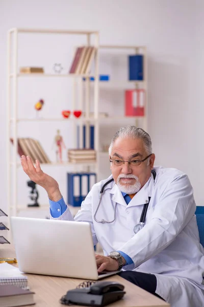 Starý lékař pracující na klinice — Stock fotografie