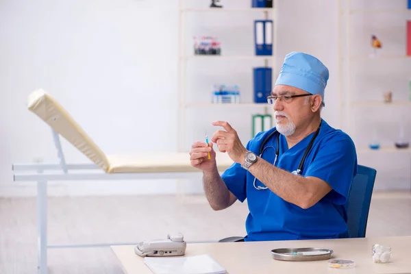 Gammal manlig läkare som arbetar på kliniken — Stockfoto