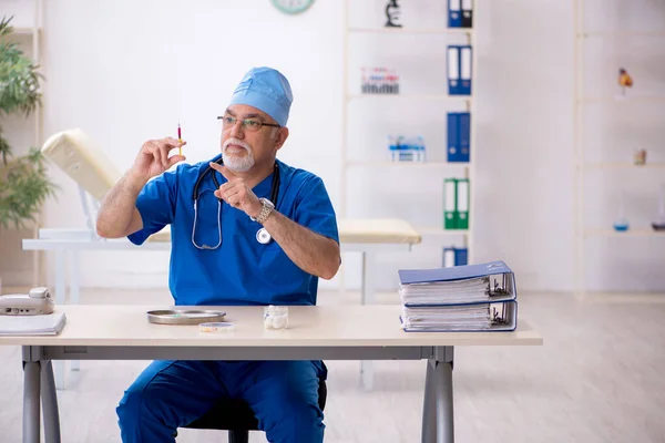 Klinikte çalışan yaşlı erkek doktor. — Stok fotoğraf