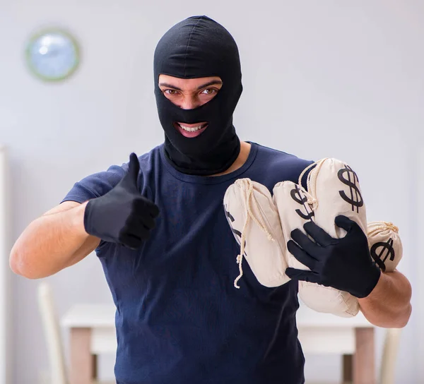 Ladrão usando balaclava roubando coisas valiosas — Fotografia de Stock