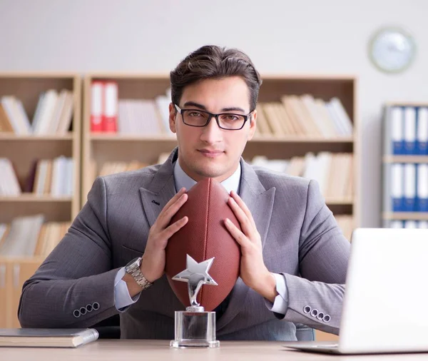 Empresário com futebol americano no escritório — Fotografia de Stock