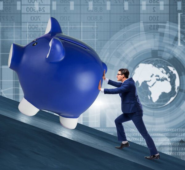 Man pushing piggybank uphill in business concept