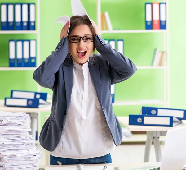 Jonge vrouwelijke werknemer zeer druk met doorlopend papierwerk — Stockfoto