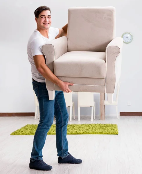 Young man moving furniture at home