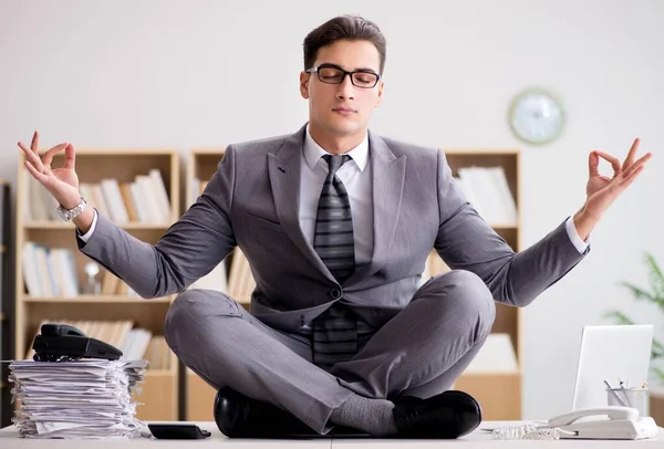 Young businessman meditating in the office — Stock Photo, Image