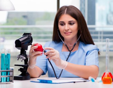 Laboratuvarda kırmızı kalpli genç bir doktor var.