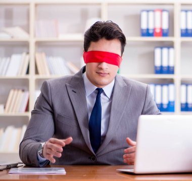 Ofiste masasında oturan gözü bağlı iş adamı.