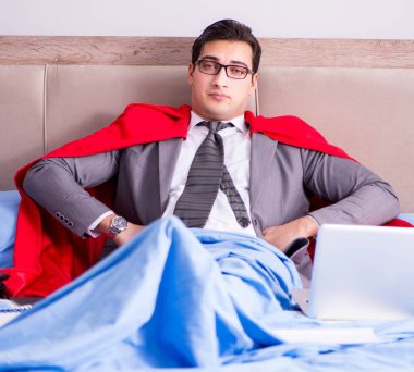 Süper kahraman iş adamı yatağından çalışıyor.