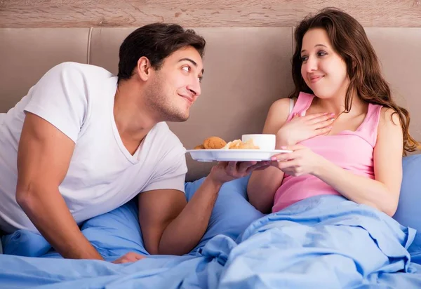 Familia feliz desayunando en la cama — Foto de Stock