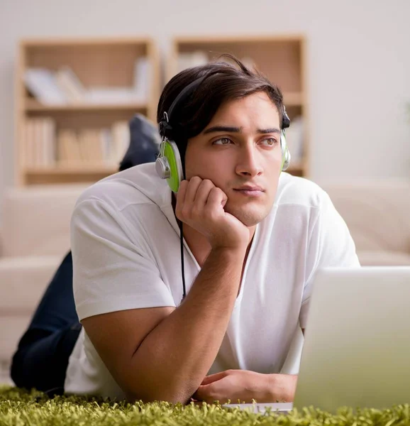 Joven escuchando la música de la computadora portátil —  Fotos de Stock