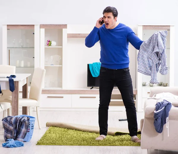 Mladý muž sbírá špinavé oblečení na prádlo — Stock fotografie