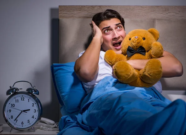 Young man scared in bed — Stock Photo, Image