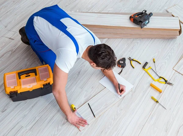 Reparador que estabelece piso laminado em casa — Fotografia de Stock