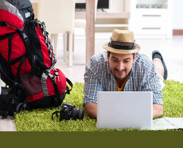 Genç adam internetten seyahat etmeyi planlıyor.