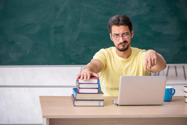 Joven estudiante masculino preparándose para los exámenes en el aula —  Fotos de Stock