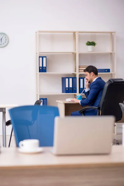 Joven empleado masculino y demasiado trabajo en la oficina —  Fotos de Stock