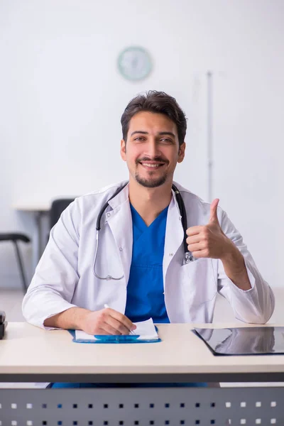 Jovem médico do sexo masculino trabalhando na clínica — Fotografia de Stock