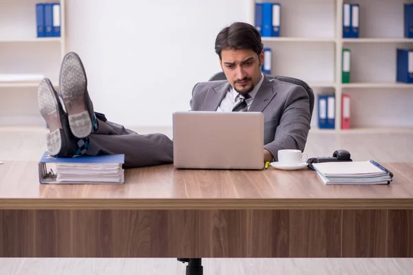 Jeune homme attrayant assis sur le lieu de travail — Photo