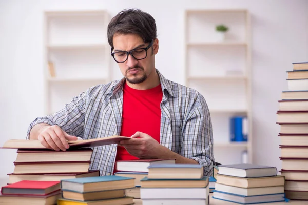 Joven estudiante masculino y demasiados libros en el aula —  Fotos de Stock