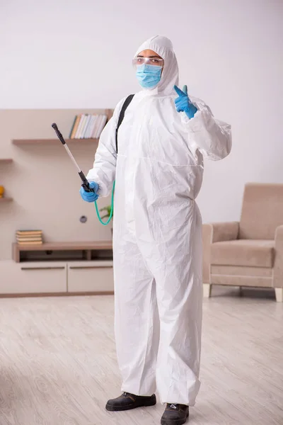 Young male contractor disinfecting at home — Stok fotoğraf