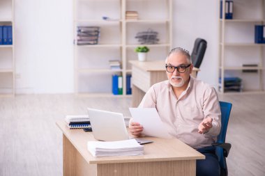 İş yerinde çalışan yaşlı bir erkek işçi.