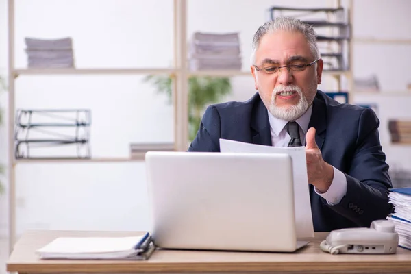 Gammal manlig anställd missnöjd med överdrivet arbete på kontoret — Stockfoto